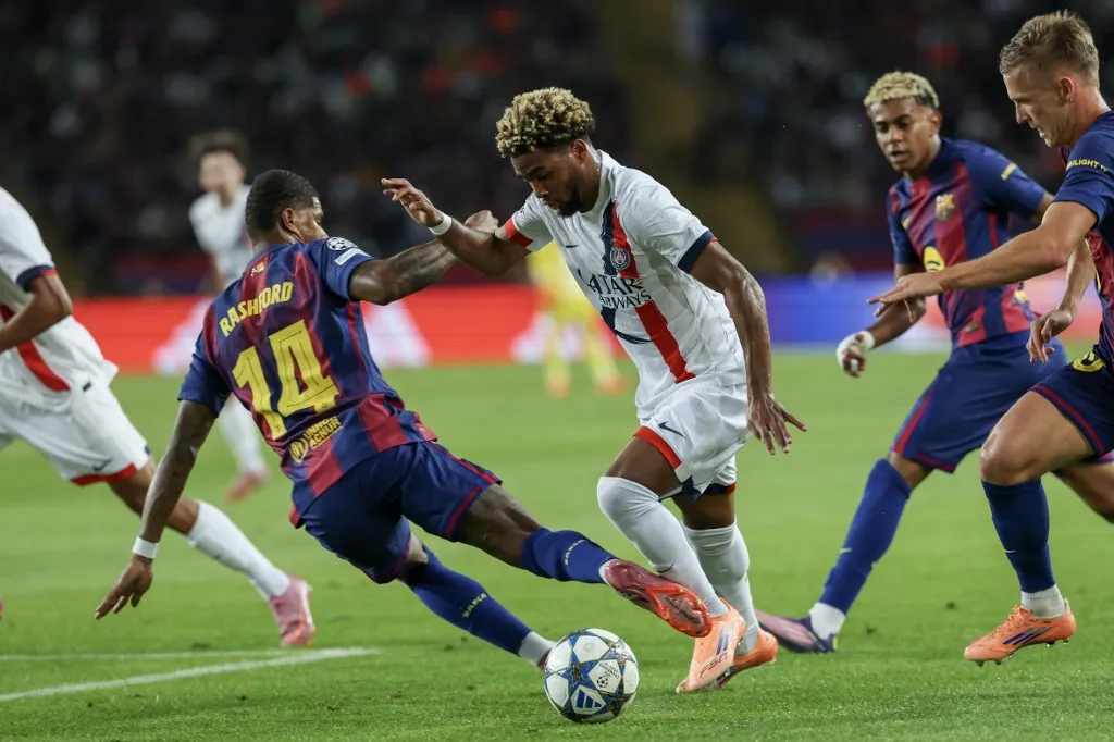 Paris Saint-Germain's French forward #10 Ousmane Dembele (C) vies for the ball with Barcelona's English forward #14 Marcus Rashford during the UEFA Champions League league phase day 2 football match between FC Barcelona and Paris Saint-Germain (PSG) at the Estadi Olimpic Lluis Companys in Barcelona, on October 1, 2025. (Photo by Lluis GENE / AFP)