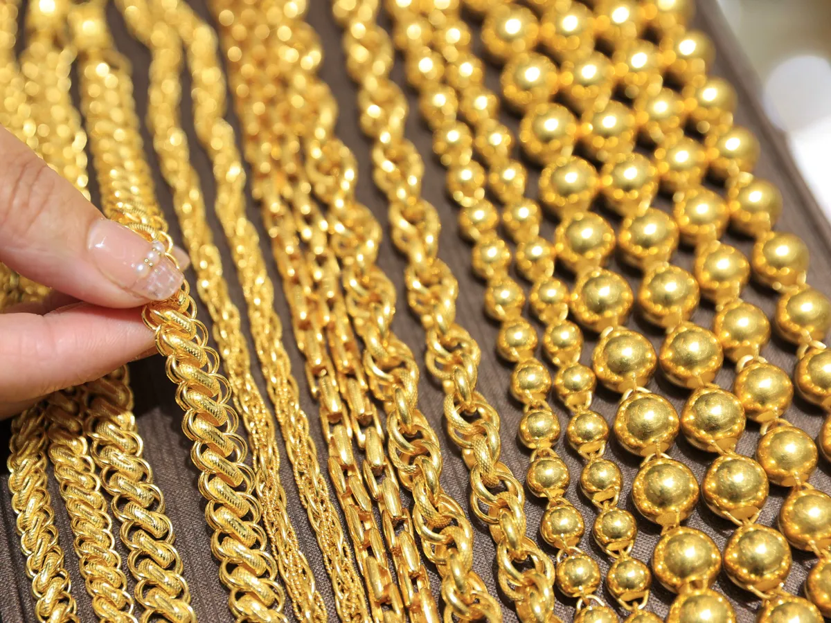 aranyékszer, arany, ékszer  A staff member is displaying gold jewelry at a gold store in Ganyu District, Lianyungang City, Jiangsu Province, China on October 14, 2025. (Photo by Si Wei / CFOTO via AFP)