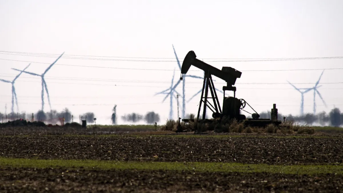 Corpus Christi, Texas, CorpusChristiTexas,   An oil pump jack in a field with wind turbines in Corpus Christi, Texas, U.S., Friday, Feb. 19, 2021. Natural gas futures fluctuated Friday as an energy crisis plaguing the central U.S. eased amid an outlook for milder weather and a decline in blackouts. Photographer: Eddie Seal/Bloomberg via Getty Images, energia