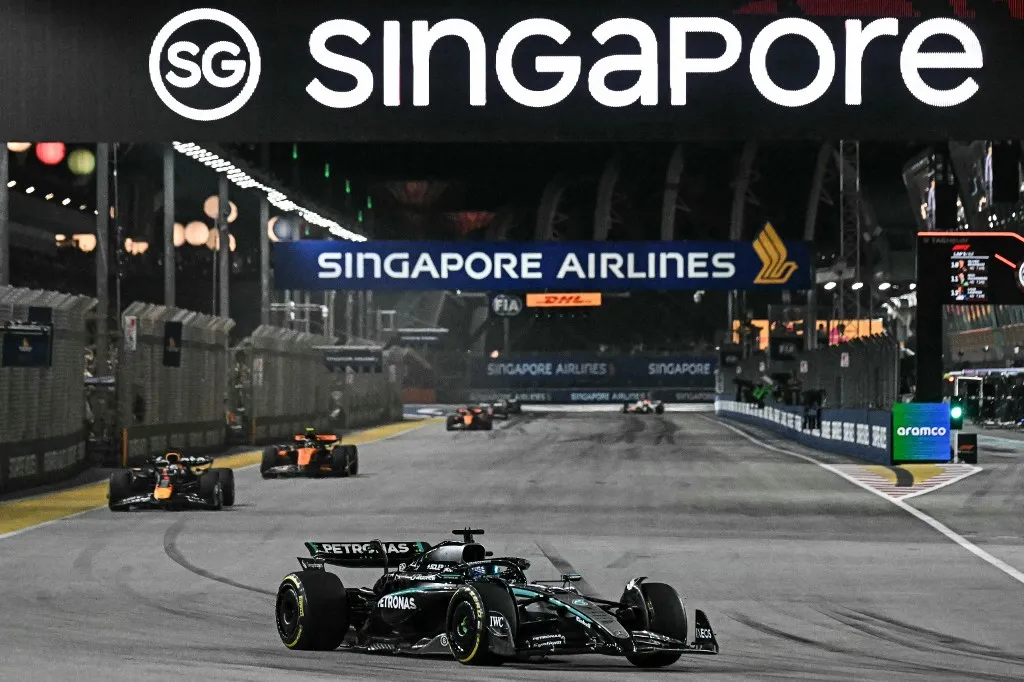 Mercedes' British driver George Russell leads ahead of Red Bull Racing's Dutch driver Max Verstappen during the Formula One Singapore Grand Prix night race at the Marina Bay Street Circuit in Singapore on October 5, 2025. (Photo by Lillian SUWANRUMPHA / AFP)