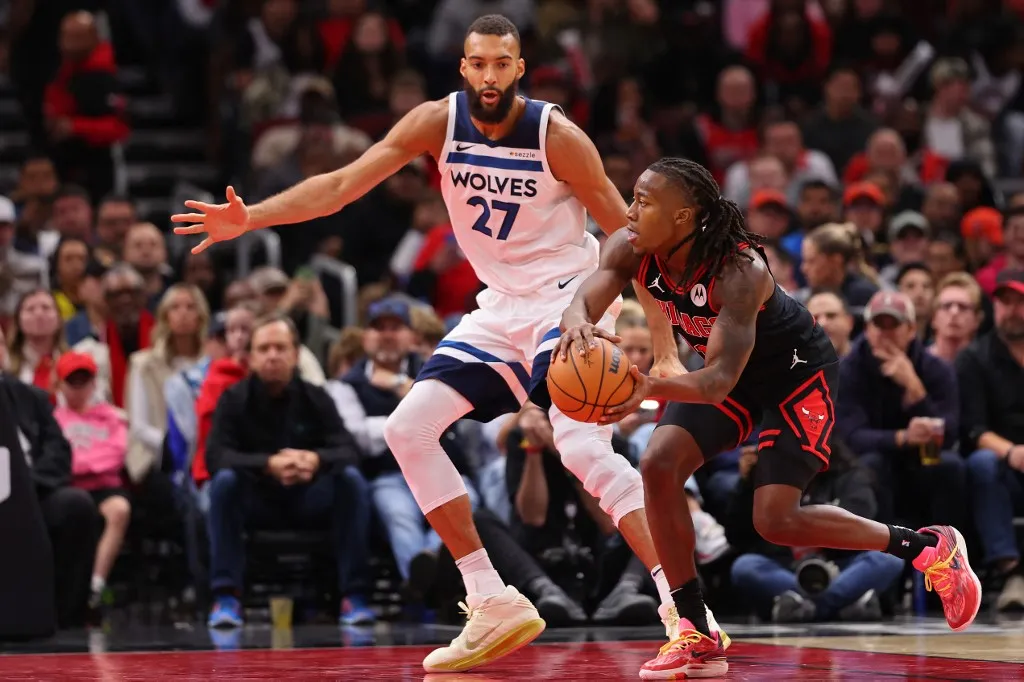 CHICAGO, ILLINOIS - NOVEMBER 07: Ayo Dosunmu #11 of the Chicago Bulls passes around Rudy Gobert #27 of the Minnesota Timberwolves during the second half at the United Center on November 07, 2024 in Chicago, Illinois. NOTE TO USER: User expressly acknowledges and agrees that, by downloading and or using this photograph, User is consenting to the terms and conditions of the Getty Images License Agreement. Michael Reaves/Getty Images/AFP (Photo by Michael Reaves / GETTY IMAGES NORTH AMERICA / Getty Images via AFP)