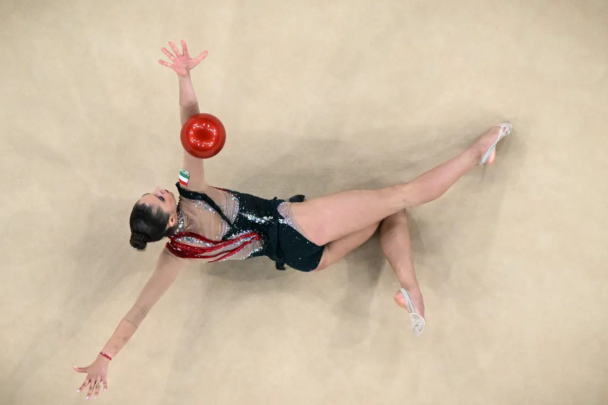 An overview shows Hungary's Fanni Pigniczki performing with the ball in the rhytmic gymnastics' individual all-around qualification during the Paris 2024 Olympic Games at the Porte de la Chapelle Arena in Paris, on August 8, 2024. (Photo by Lionel BONAVENTURE / AFP)