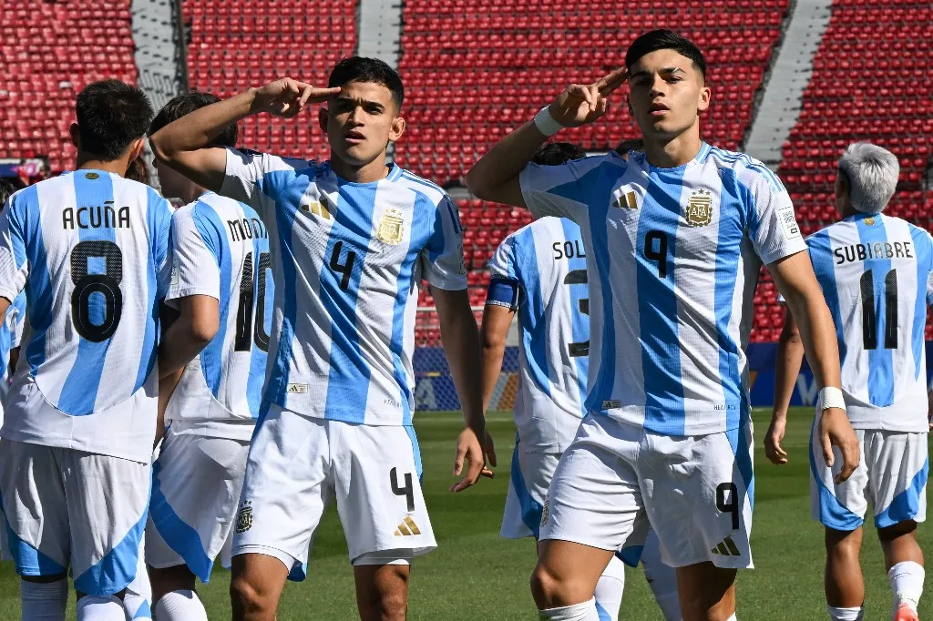 Argentina's forward #09 Alejo Sarco celebrates with teammate defender #04 Dylan Gorosito after scoring his team's first goal during the 2025 FIFA U-20 World Cup round of 16 football match between Argentina and Nigeria at the National Stadium in Santiago on October 8, 2025. (Photo by RODRIGO ARANGUA / AFP)