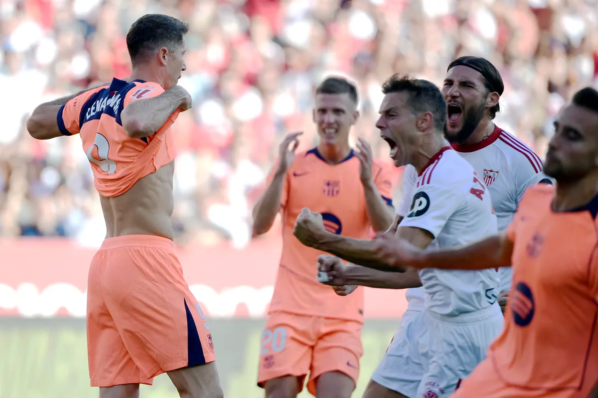 Barcelona's Polish forward #09 Robert Lewandowski (L) reacts to missing a penalty kick during the Spanish league football match between Sevilla FC and FC Barcelona at Ramon Sanchez Pizjuan Stadium in Seville on October 5, 2025. (Photo by CRISTINA QUICLER / AFP)