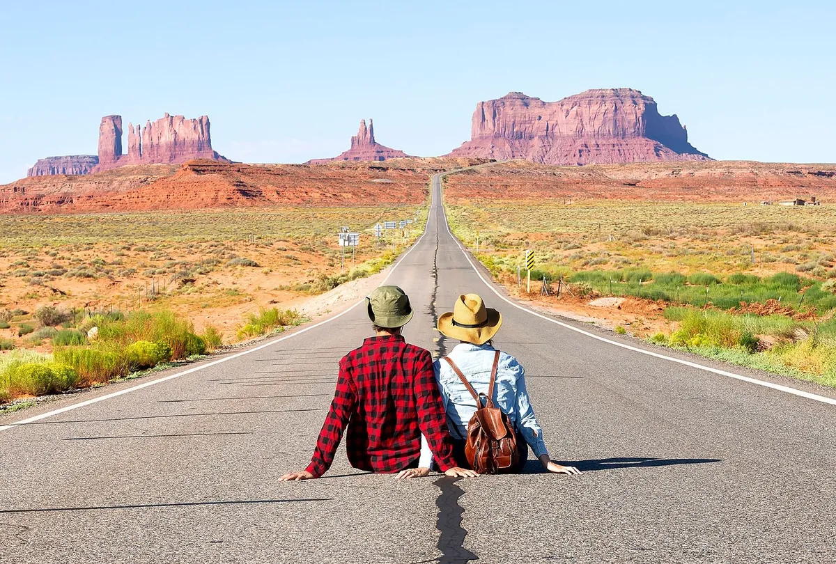Happy couple on the famous road to Monument Valley in Utah. Amazing view of the Monument valley