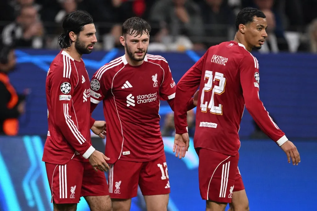 Liverpool's Hungarian midfielder #08 Dominik Szoboszlai (L-R) celebrates scoring the 1-5 goal with his teammates Liverpool's Northern Irish defender #12 Conor Bradley and Liverpool's French striker #22 Hugo Ekitike during the UEFA Champions League football match between Eintracht Frankfurt and Liverpool FC in Frankfurt, western Germany on October 22, 2025. (Photo by Kirill KUDRYAVTSEV / AFP)