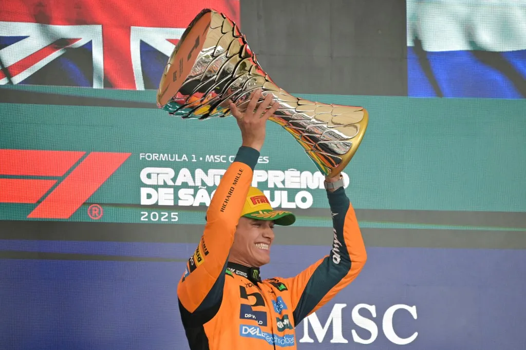 McLaren's British driver Lando Norris lifts the trophy on the podium after winning the Sao Paulo Formula One Grand Prix at the Jose Carlos Pace racetrack, aka Interlagos, in Sao Paulo, Brazil on November 9, 2025. (Photo by Nelson ALMEIDA / AFP)
