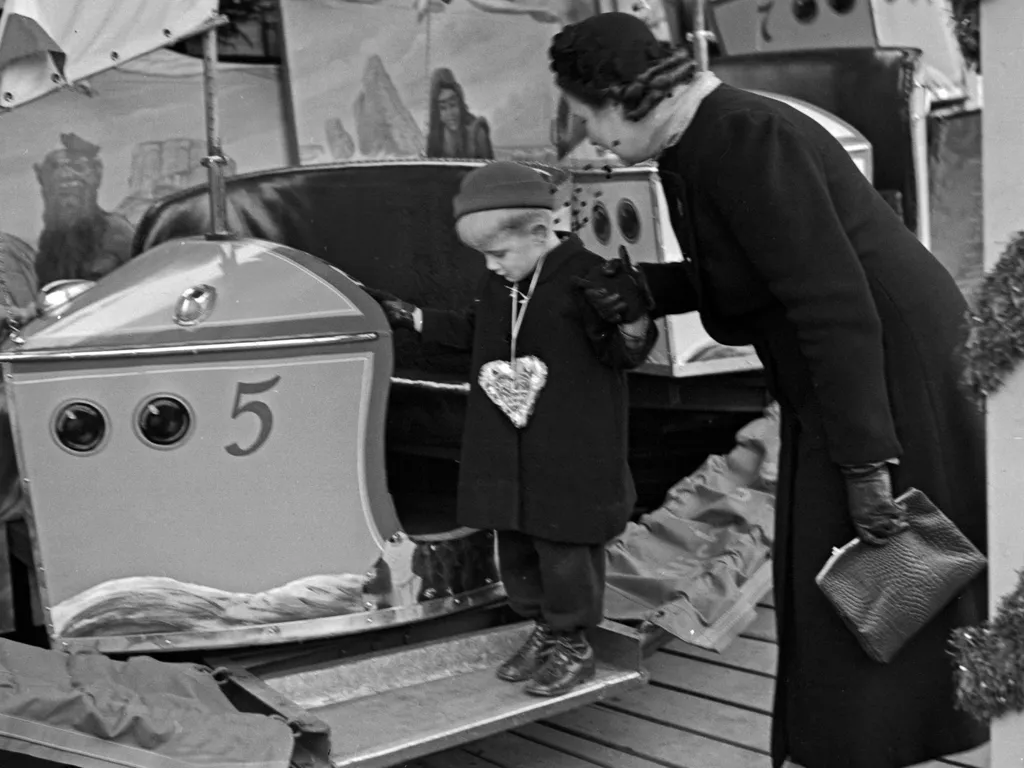 karácsonyivásár, karácsonyi vásár,
A little boy and his mother standing by a kiddy carousel at the christmas market, Germany 1930s. (Photo by Heinz Pollmann / United Archives/Pollmann / mauritius images via AFP)