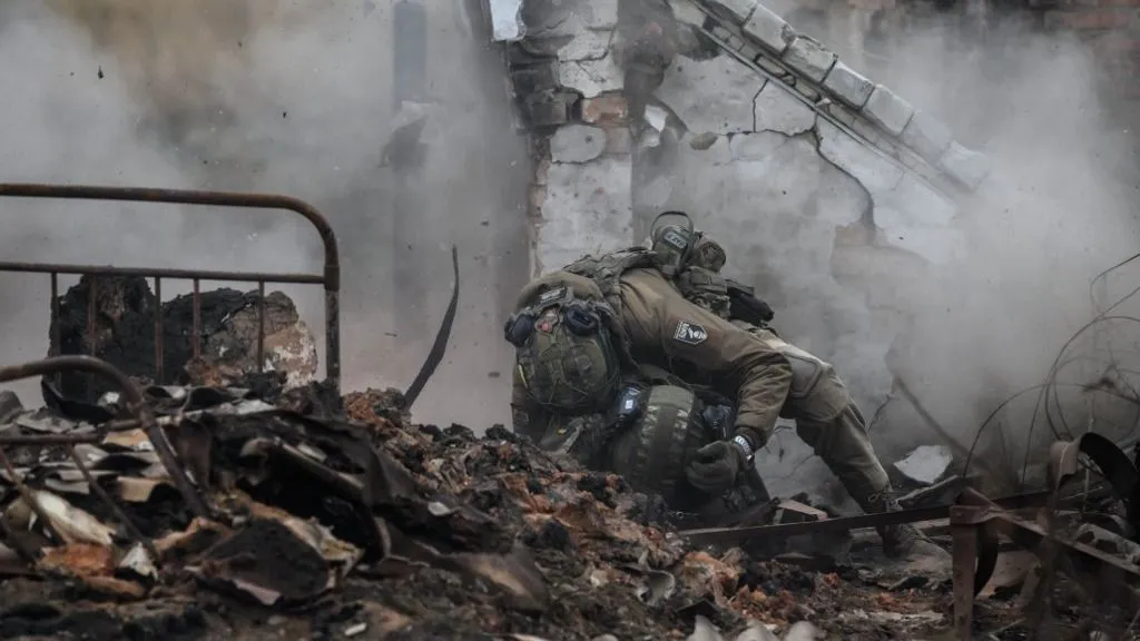 Infantry recruits of the 28th Seperate Mechanized Brigade take cover from a grenade blast as they undergo a basic training course at an undislosed location in eastern Ukraine on October 9, 2025. (Photo by Ed JONES / AFP)