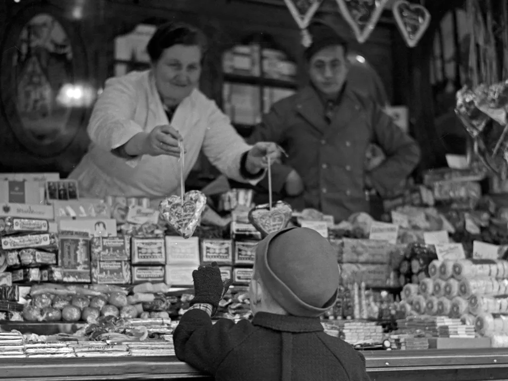 karácsonyivásár, karácsonyi vásár,
A little boy standing and shopping at the candy booth at the christmas market, Germany 1930s. (Photo by Heinz Pollmann / United Archives/Pollmann / mauritius images via AFP)