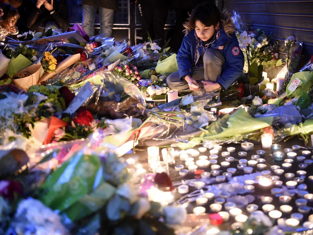 2015-öspárizsiterrortámadás, 2015-ös párizsi terrortámadás, Párizs, 2015, terrortámadás,   A youth looks at floral tributes laid near the "Belle Equipe" restaurant, the site of one of the attacks in Paris on November 14, 2015.  Islamic State jihadists  cl