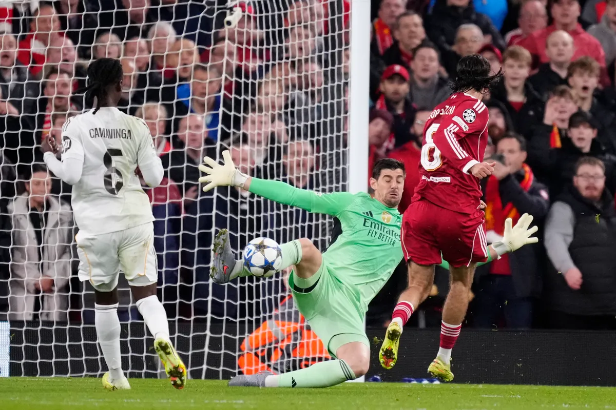 Dominik Szoboszlai attacking midfield of Liverpool and Hungary shooting to goal and Thibaut Courtois goalkeeper of Real Madrid and Belgium makes a save during the UEFA Champions League 2025/26 League Phase MD4 match between Liverpool FC and Real Madrid C.F. at Anfield on November 4, 2025 in Liverpool, United Kingdom. (Photo by Jose Breton/Pics Action/NurPhoto) (Photo by Jose Breton / NurPhoto via AFP)