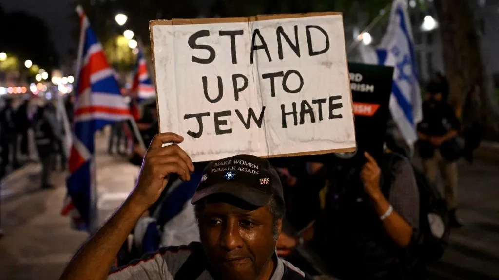Tiltakozók zászlókat lengetnek a Campaign Against Antisemitism (Antiszemitizmus Elleni Kampány) által szervezett tüntetésen