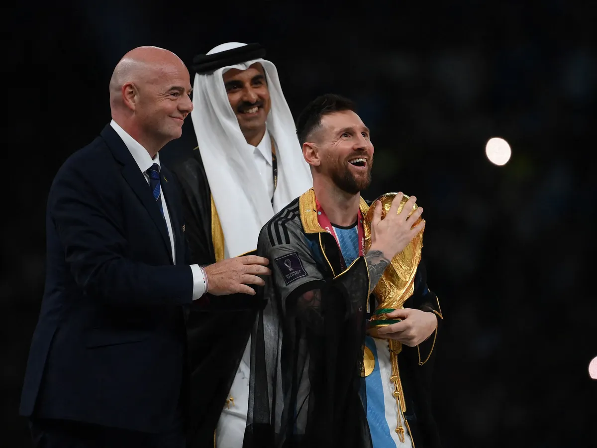 Argentina's forward #10 Lionel Messi holds the World Cup trophy after receiving it from FIFA President Gianni Infantino and Qatar's Emir Sheikh Tamim bin Hamad al-Thani during the Qatar 2022 World Cup trophy ceremony after the football final match between Argentina and France at Lusail Stadium in Lusail, north of Doha on December 18, 2022. Argentina won in the penalty shoot-out. (Photo by FRANCK FIFE / AFP)