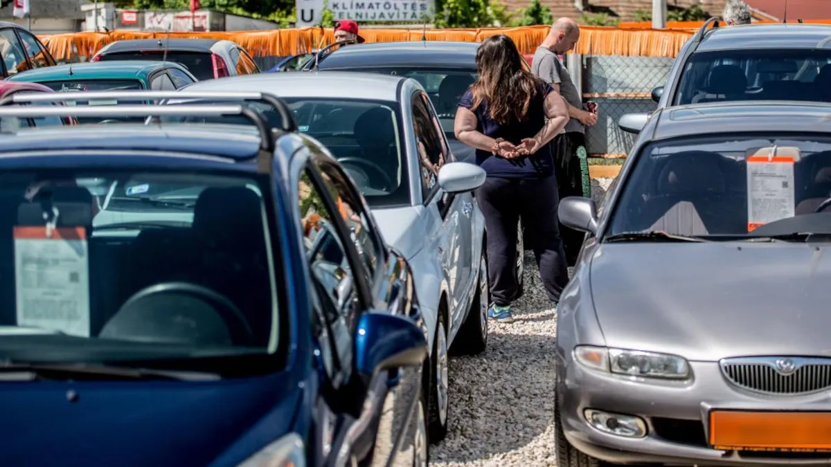 Nézelődők egy használt autó kereskedésben, adásvételi szerződés megkötése előtt.
