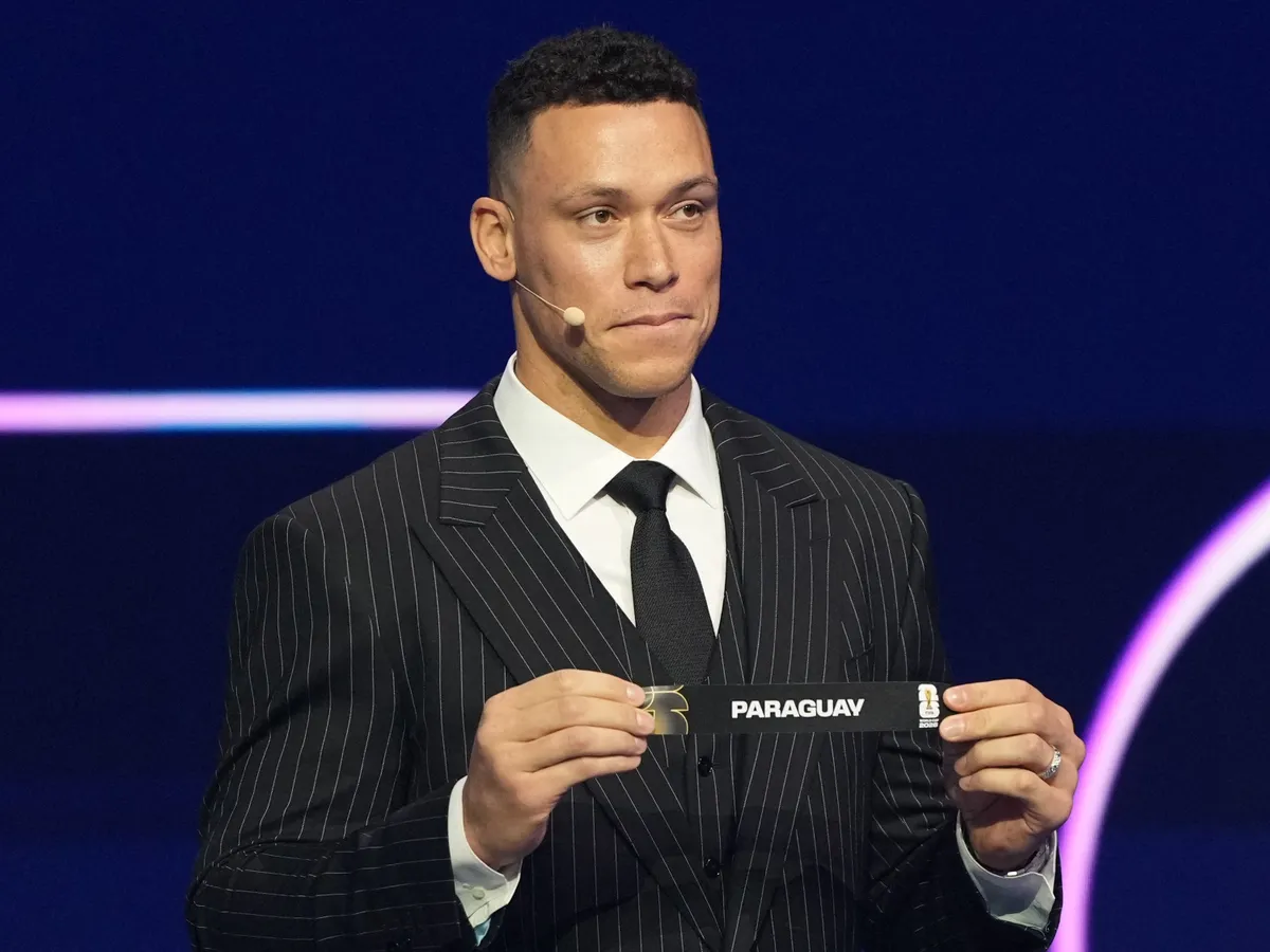 US Draw assistant Aaron Judge shows the card reading Paraguay during the draw for the 2026 FIFA Football World Cup taking place in the US, Canada and Mexico, at the Kennedy Center, in Washington, DC, on December 5, 2025. (Photo by Stephanie Scarbrough / POOL / AFP)