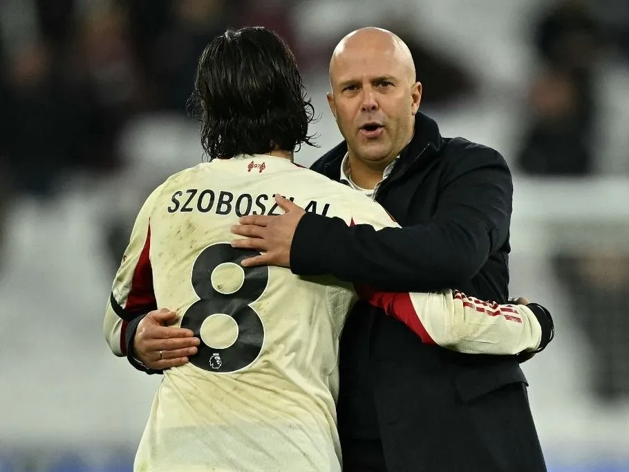 Liverpool's Dutch manager Arne Slot (R) embraces Liverpool's Hungarian midfielder #08 Dominik Szoboszlai (L) on the pitch after the English Premier League football match between West Ham United and Liverpool at the London Stadium, in London on November 30, 2025. Liverpool won the game 2-0. (Photo by Ben STANSALL / AFP) / RESTRICTED TO EDITORIAL USE. No use with unauthorized audio, video, data, fixture lists, club/league logos or 'live' services. Online in-match use limited to 120 images. An additional 40 images may be used in extra time. No video emulation. Social media in-match use limited to 120 images. An additional 40 images may be used in extra time. No use in betting publications, games or single club/league/player publications. / 