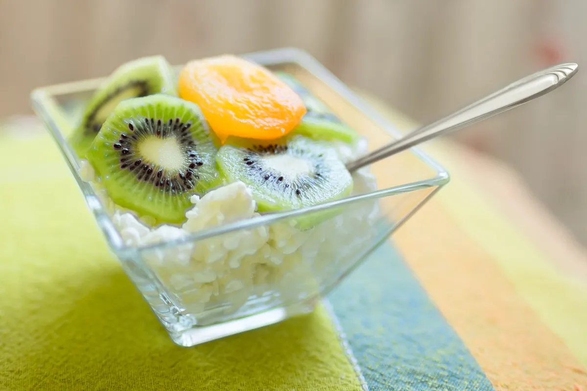 Dessert with cottage cheese, kiwi and dried apricot in a glass