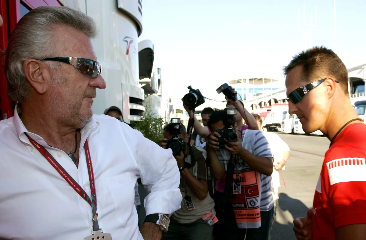 German Formula One pilot Michael Schumacher (R) of Scuderia Ferrari exchanges glances with his manager German Willi Weber (L) in the paddock of the Istanbul Park circuit near Istanbul, Turkey, Friday, 25 August 2006. The Formula 1 Turkish Grand Prix will be held on Sunday, 27 August. Photo: Rainer Jensen (Photo by RAINER JENSEN / dpa Picture-Alliance via AFP)