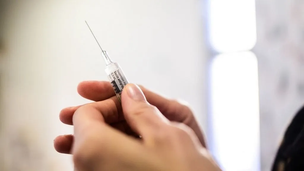 Close-up view of a pharmacist s hand holding a pre-filled syringe of flu vaccine before injection in a pharmacy in Pau, France, on December 8, 2025. The image highlights the hands and the needle, with the mention of the flu vaccine. It illustrates the problem of the virulent seasonal flu epidemic and the potential shortage of the medication or the vaccination campaign against the winter virus.
Vue rapprochee d une main de pharmacienne tenant une seringue preremplie de vaccin contre la grippe avant l injection dans une pharmacie a Pau en France le 8 Decembre 2025. L image met en avant les mains et l aiguille avec mention relative au vaccin antigrippal. Elle illustre la problematique de l epidemie saisonniere virulente de la grippe ainsi que la potentielle penurie du medicament ou de la campagne de vaccination contre le virus hivernal. (Photo by Quentin Top / Hans Lucas via AFP)