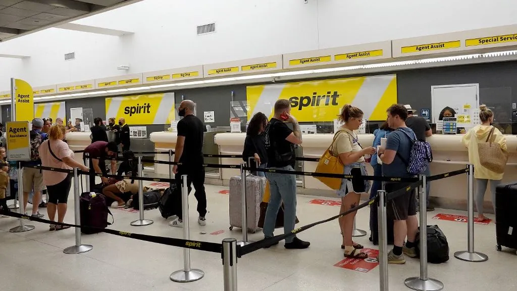 FORT LAUDERDALE, FLORIDA - MAY 16: People stand in line to check-in at the Spirit Airlines counter in the Fort Lauderdale-Hollywood International Airport on May 16, 2022 in Fort Lauderdale, Florida. JetBlue announced it is taking a hostile position in its effort to acquire Spirit Airlines. Spirit previously rejected a takeover offer from JetBlue, favoring an earlier deal to merge with Frontier airlines. Joe Raedle/Getty Images/AFP (Photo by JOE RAEDLE / GETTY IMAGES NORTH AMERICA / Getty Images via AFP)