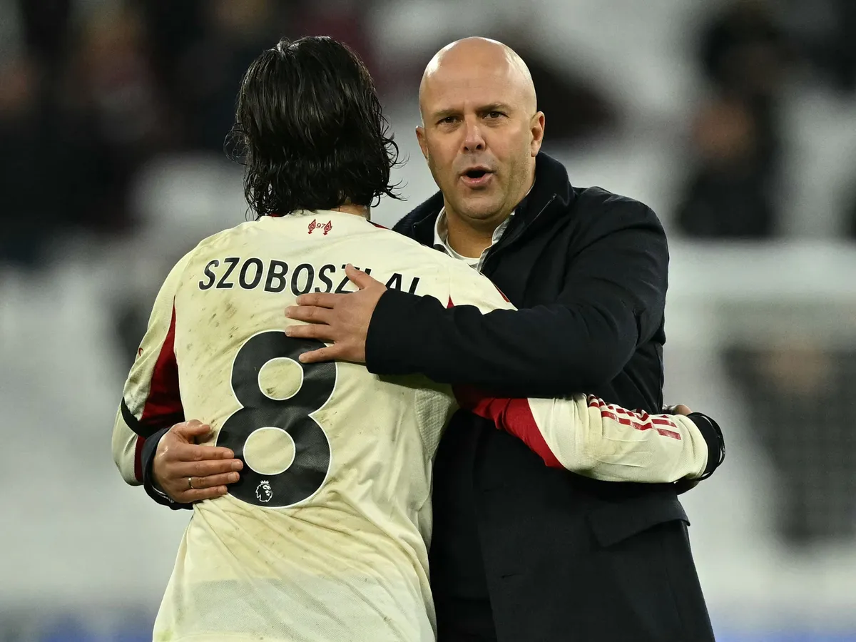 Liverpool's Dutch manager Arne Slot (R) embraces Liverpool's Hungarian midfielder #08 Dominik Szoboszlai (L) on the pitch after the English Premier League football match between West Ham United and Liverpool at the London Stadium, in London on November 30, 2025. Liverpool won the game 2-0. (Photo by Ben STANSALL / AFP) / RESTRICTED TO EDITORIAL USE. No use with unauthorized audio, video, data, fixture lists, club/league logos or 'live' services. Online in-match use limited to 120 images. An additional 40 images may be used in extra time. No video emulation. Social media in-match use limited to 120 images. An additional 40 images may be used in extra time. No use in betting publications, games or single club/league/player publications. /