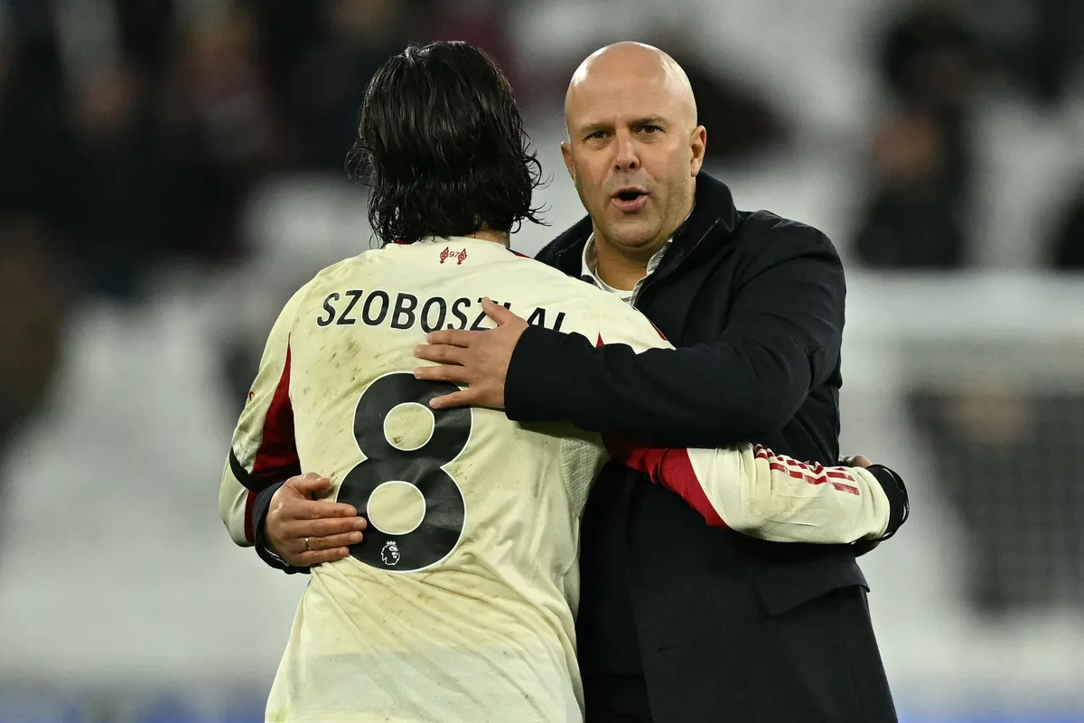 Liverpool's Dutch manager Arne Slot (R) embraces Liverpool's Hungarian midfielder #08 Dominik Szoboszlai (L) on the pitch after the English Premier League football match between West Ham United and Liverpool at the London Stadium, in London on November 30, 2025. Liverpool won the game 2-0. (Photo by Ben STANSALL / AFP) / RESTRICTED TO EDITORIAL USE. No use with unauthorized audio, video, data, fixture lists, club/league logos or 'live' services. Online in-match use limited to 120 images. An additional 40 images may be used in extra time. No video emulation. Social media in-match use limited to 120 images. An additional 40 images may be used in extra time. No use in betting publications, games or single club/league/player publications. / 