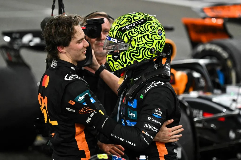 McLarens British driver Lando Norris (R) celebrates with his team's Australian driver Oscar Piastri after winning the world championship title at the end of the Abu Dhabi Formula One Grand Prix at the Yas Marina Circuit in Abu Dhabi on December 7, 2025. (Photo by Andrej ISAKOVIC / AFP)