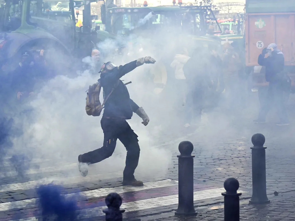 Gazdatüntetés Brüsszelben, GazdatüntetésBrüsszelben, Gazdatüntetés, Brüsszel, mezőgazdaság,
A farmer throws a stone as farmers clash with police officers near the European Parliament, during a farmers' protest to denounce the reforms of the Common Agri