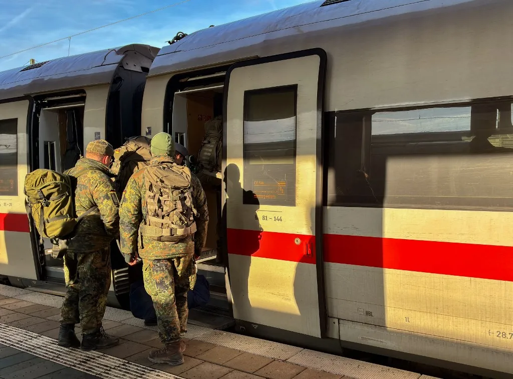 Several German Bundeswehr soldiers wear camouflage uniforms and large backpacks as they board an ICE train car on a platform in Munich, Bavaria, Germany, on December 12, 2025. (Photo by Michael Nguyen/NurPhoto) (Photo by Michael Nguyen / NurPhoto via AFP)