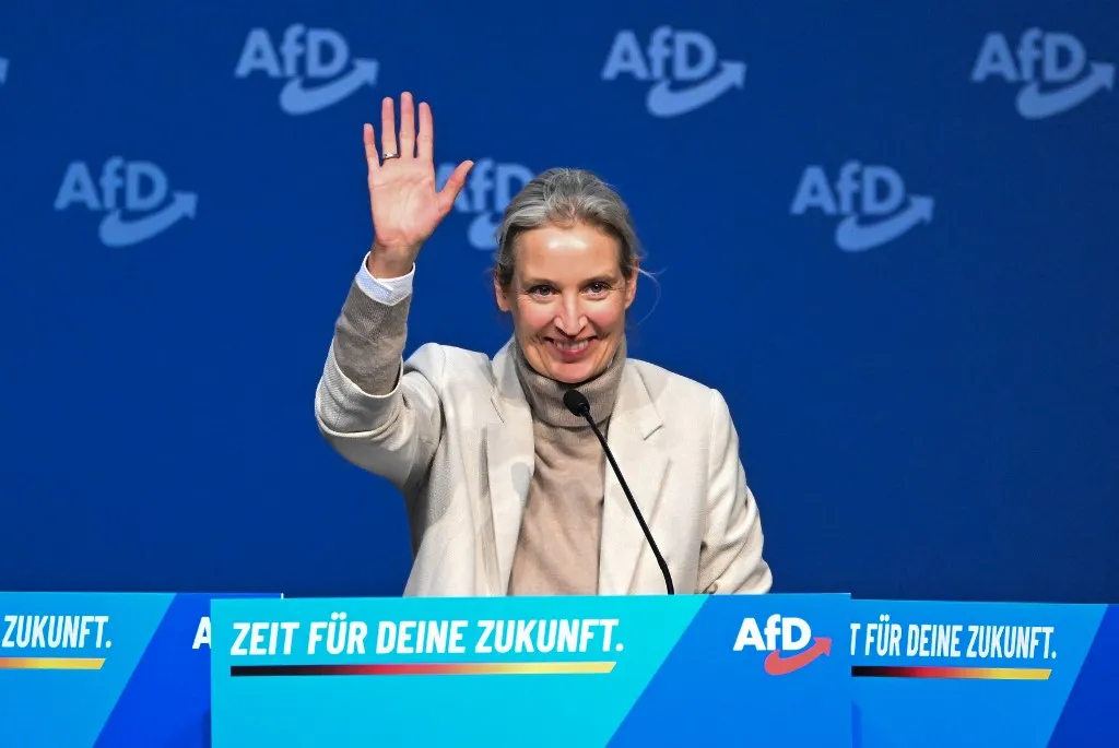 AfD co-leader Alice Weidel waves to party members and delegates as she stands on the podium to deliver a speech during a two-day convention of far-right Alternative for Germany (AfD) party to establish its new youth organisation at the exhibition halls in Giessen, Germany on November 29, 2025. (Photo by Kirill KUDRYAVTSEV / AFP)