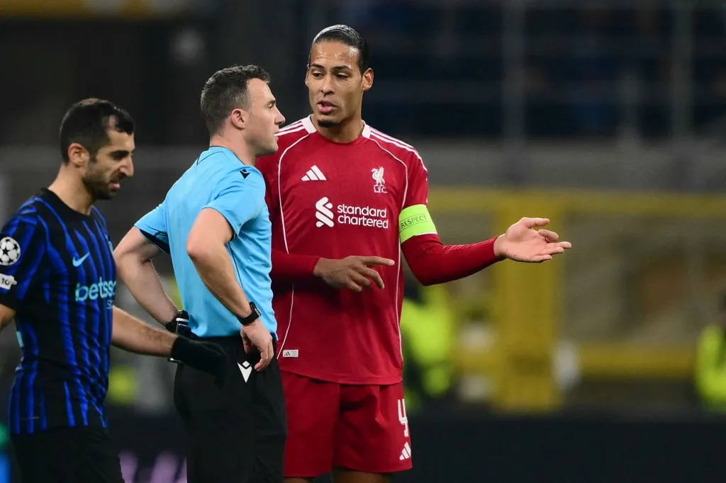 Liverpool's Dutch defender #04 Virgil van Dijk speaks with German referee Felix Zwayer at half-time during the UEFA Champions League phase day 6 football match between Inter Milan and Liverpool at San Siro stadium in Milan, on December 9, 2025. (Photo by Marco BERTORELLO / AFP)