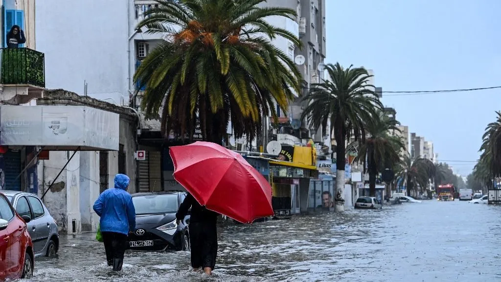 tunéziai áradások - Residents make their way through flood waters, in La Goulette near the capital Tunis, on Januray 20, 2026. Flooding across Tunisia has killed three people, authorities said January 20, with one official reporting a "critical" situation as parts of the North African country experienced their heaviest rainfall in more than 70 years. (Photo by FETHI BELAID / AFP)
