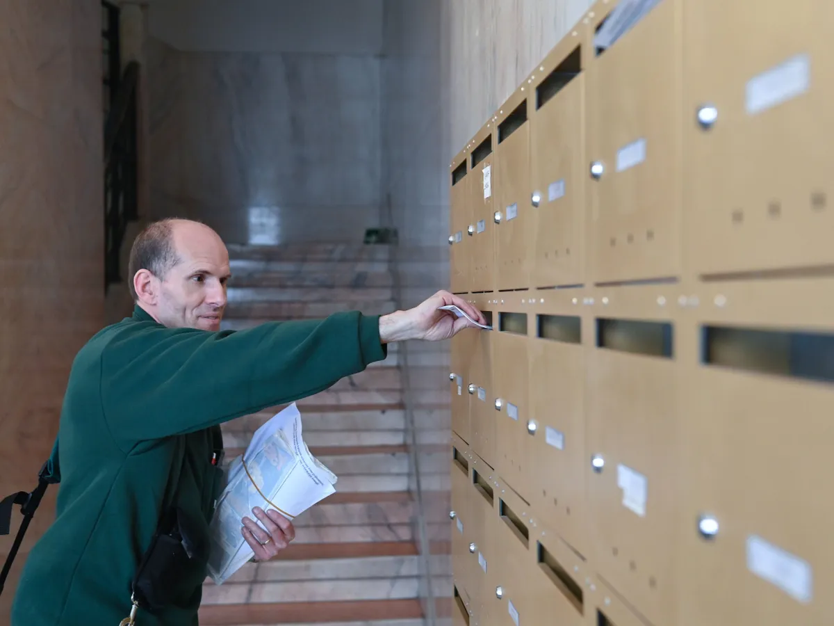 A Magyar Posta kézbesítője az idei európai parlamenti, helyi önkormányzati, valamint a nemzetiségi önkormányzati választásokra érvényes szavazóköri névjegyzékbe vételről szóló értesítőt dob postaládába egy budapesti társasházban 2024. április 5-én. A Nemzeti Választási Iroda (NVI) az április 3-i névjegyzéki adatok alapján megkezdte az értesítők kiküldését.
MTI/Máthé Zoltán