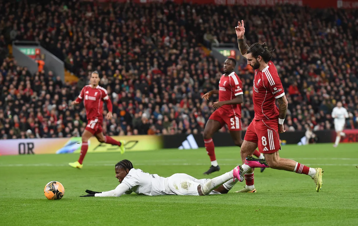 Barnsley's English striker #19 Reyes Cleary goes down in the area following a challenge by Liverpool's Hungarian midfielder #08 Dominik Szoboszlai, but no penalty is awarded, during the English FA Cup third round football match between Liverpool and Barnsley at Anfield in Liverpool, north west England on January 12, 2026. (Photo by PETER POWELL / AFP) / RESTRICTED TO EDITORIAL USE. No use with unauthorized audio, video, data, fixture lists, club/league logos or 'live' services. Online in-match use limited to 120 images. An additional 40 images may be used in extra time. No video emulation. Social media in-match use limited to 120 images. An additional 40 images may be used in extra time. No use in betting publications, games or single club/league/player publications. / 