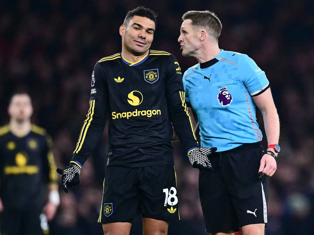 Manchester United's Brazilian midfielder #18 Casemiro (C) is told off by the referee during the English Premier League football match between Arsenal and Manchester United at the Emirates Stadium in London on January 25, 2026. (Photo by Ben STANSALL / AFP) / RESTRICTED TO EDITORIAL USE. No use with unauthorized audio, video, data, fixture lists, club/league logos or 'live' services. Online in-match use limited to 120 images. An additional 40 images may be used in extra time. No video emulation. Social media in-match use limited to 120 images. An additional 40 images may be used in extra time. No use in betting publications, games or single club/league/player publications. / 