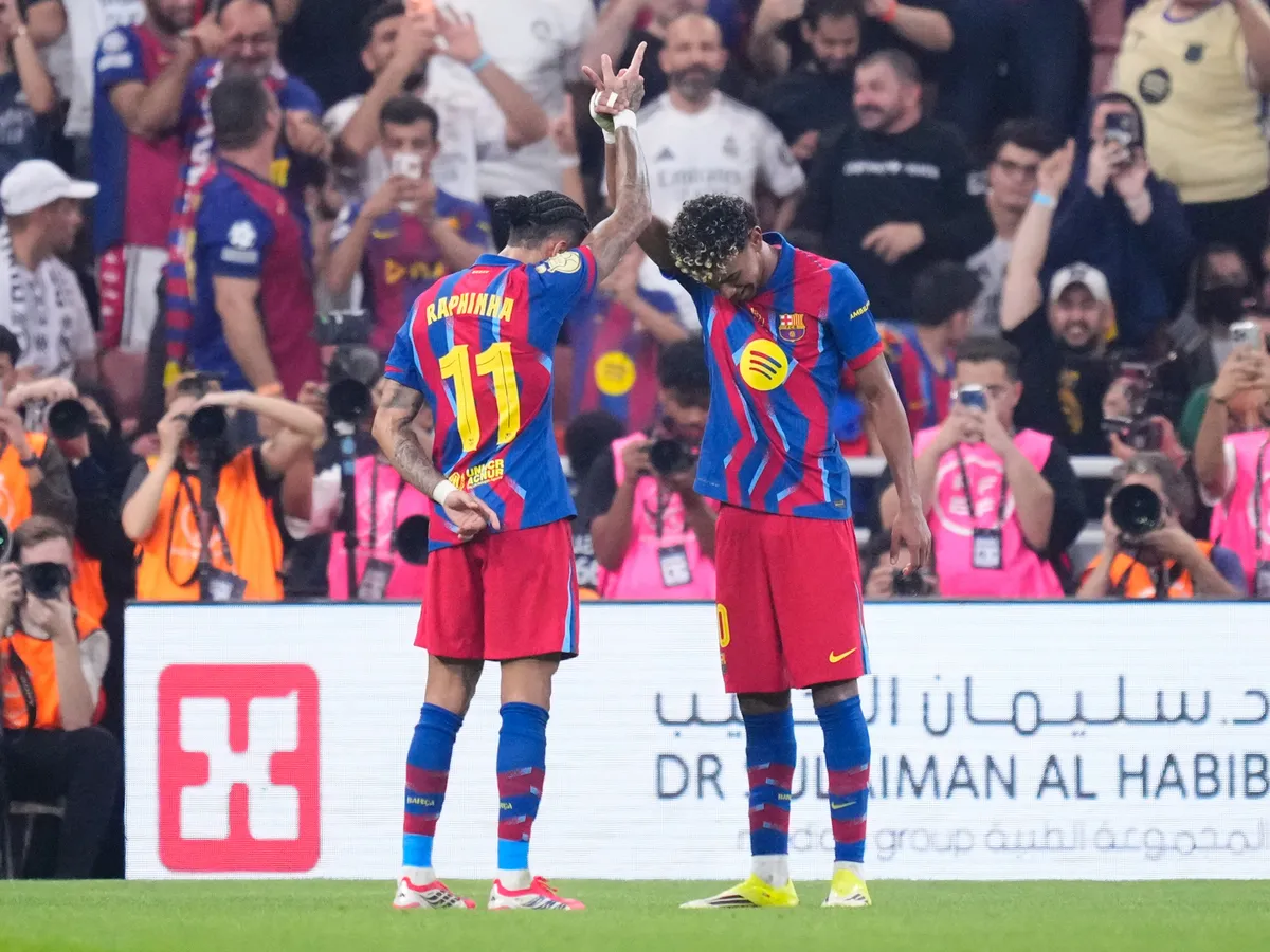 Raphinha right winger of Barcelona and Brazil celebrates with Lamine Yamal after scoring his sides first goal during the Spanish Super Cup final match between FC Barcelona and Real Madrid at King Abdullah Sports City Hall Stadium on January 11, 2026 in Jeddah, Saudi Arabia.   (Photo by Jose Breton/Pics Action/NurPhoto) (Photo by Jose Breton / NurPhoto via AFP)