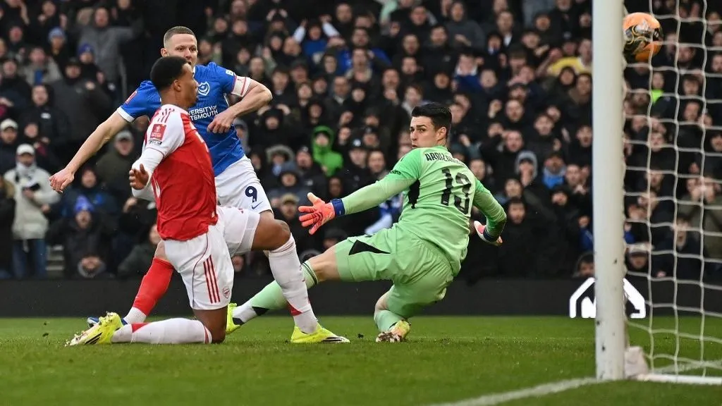 Portsmouth's English striker #09 Colby Bishop scores the opening goal past Arsenal's Spanish goalkeeper #13 Kepa Arrizabalaga during the English FA Cup third round football match between Portsmouth and Arsenal at Fratton Park in Portsmouth, southern England on January 11, 2026. (Photo by Glyn KIRK / AFP) / RESTRICTED TO EDITORIAL USE. No use with unauthorized audio, video, data, fixture lists, club/league logos or 'live' services. Online in-match use limited to 120 images. An additional 40 images may be used in extra time. No video emulation. Social media in-match use limited to 120 images. An additional 40 images may be used in extra time. No use in betting publications, games or single club/league/player publications. / 