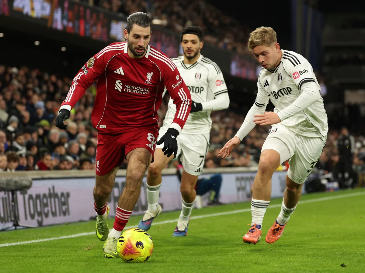 Liverpool's Hungarian midfielder #08 Dominik Szoboszlai (L) is pressured by Fulham's English midfielder #32 Emile Smith Rowe (R) during the English Premier League football match between Fulham and Liverpool at Craven Cottage in London on January 4, 2026. (Photo by Adrian Dennis / AFP) / RESTRICTED TO EDITORIAL USE. No use with unauthorized audio, video, data, fixture lists, club/league logos or 'live' services. Online in-match use limited to 120 images. An additional 40 images may be used in extra time. No video emulation. Social media in-match use limited to 120 images. An additional 40 images may be used in extra time. No use in betting publications, games or single club/league/player publications. / 