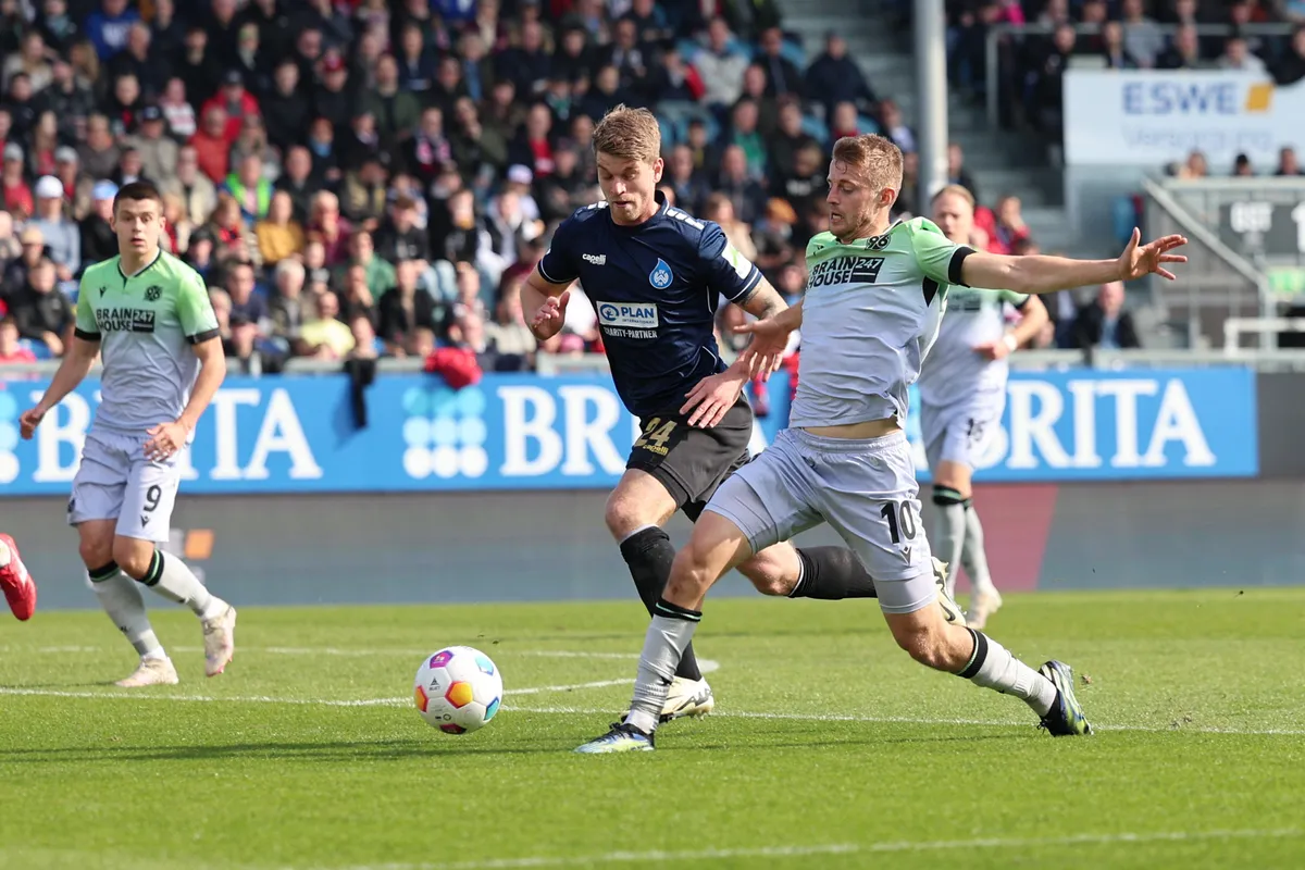 Franko Kovacevic (középen), a Fradi új csatára, itt még a német Wehen Wiesbaden színeiben igyekszik kilépni a Hannover védői között