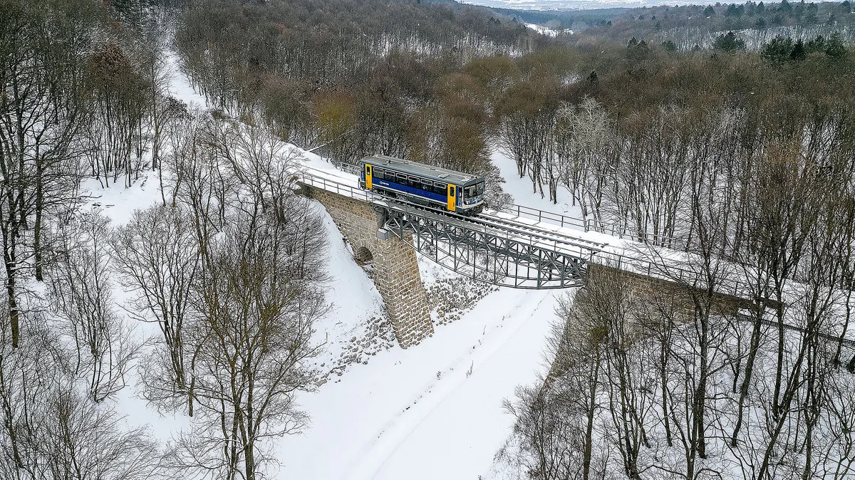 Eplény, 2026. január 7.A drónnal készült felvételen Bz motorkocsi az újjáépített eplényi viadukton a behavazott Bakonyban 2026. január 7-én.MTI/Máthé Zoltán, hó