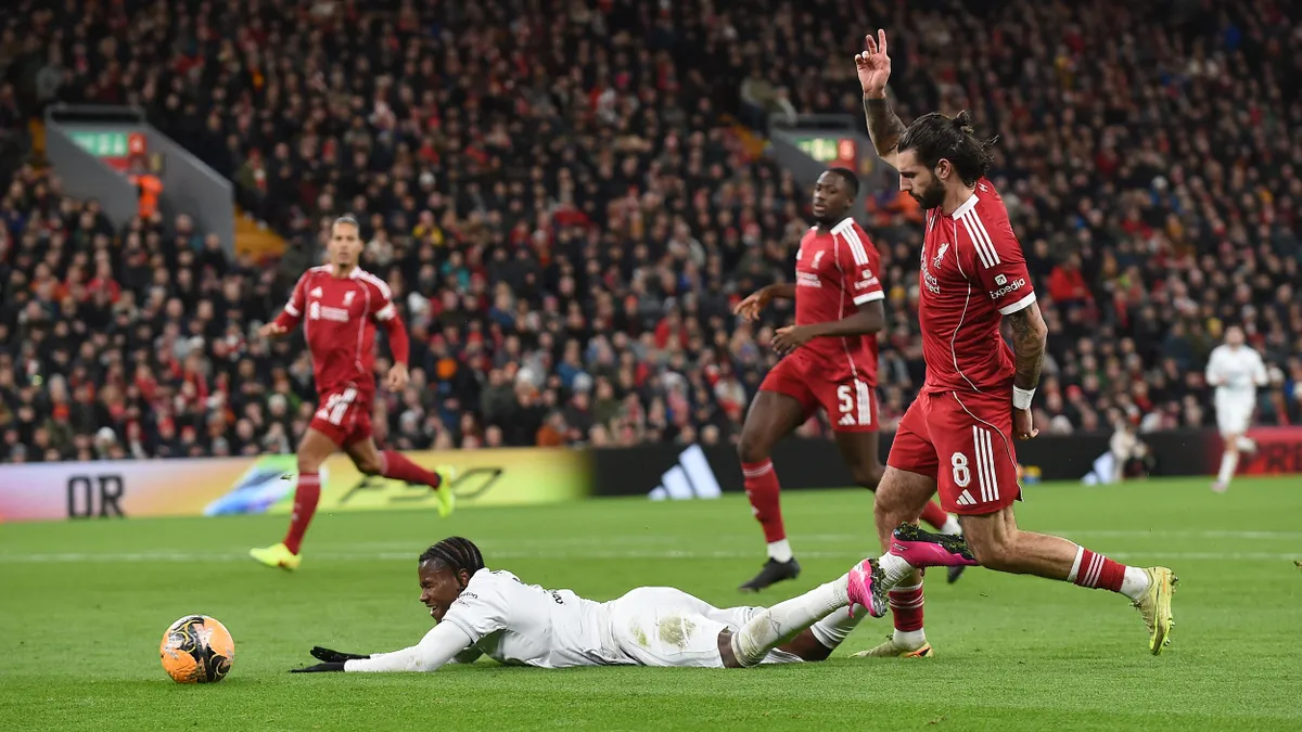 Barnsley's English striker #19 Reyes Cleary goes down in the area following a challenge by Liverpool's Hungarian midfielder #08 Dominik Szoboszlai, but no penalty is awarded, during the English FA Cup third round football match between Liverpool and Barnsley at Anfield in Liverpool, north west England on January 12, 2026. (Photo by PETER POWELL / AFP) / RESTRICTED TO EDITORIAL USE. No use with unauthorized audio, video, data, fixture lists, club/league logos or 'live' services. Online in-match use limited to 120 images. An additional 40 images may be used in extra time. No video emulation. Social media in-match use limited to 120 images. An additional 40 images may be used in extra time. No use in betting publications, games or single club/league/player publications. / 