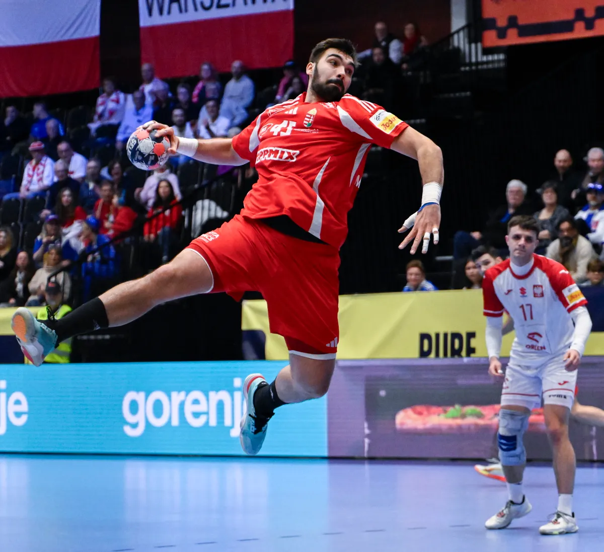 Kristianstad, 2026. január 16.
Rosta Miklós (k) és a lengyel Andrzej Widomski a dán-norvég-svéd közös rendezésű férfi kézilabda-Európa-bajnokság F csoportjának első fordulójában játszott Magyarország - Lengyelország mérkőzésen a svédországi Kristianstad Arénában 2026. január 16-án.
MTI/Hegedüs Róbert