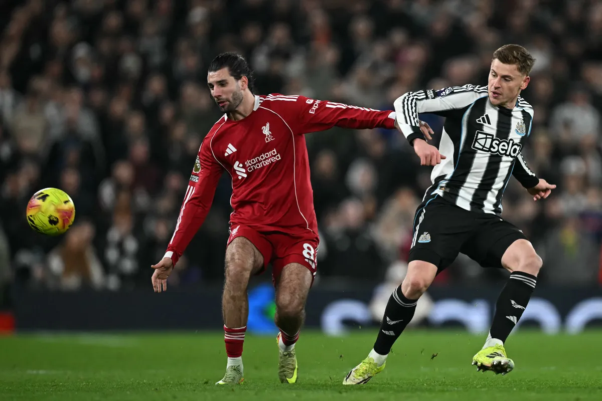 Liverpool's Hungarian midfielder #08 Dominik Szoboszlai (L) vies with Newcastle United's English midfielder #11 Harvey Barnes (R) during the English Premier League football match between Liverpool and Newcastle United at Anfield in Liverpool, north west England on January 31, 2026. (Photo by Paul ELLIS / AFP) / RESTRICTED TO EDITORIAL USE. No use with unauthorized audio, video, data, fixture lists, club/league logos or 'live' services. Online in-match use limited to 120 images. An additional 40 images may be used in extra time. No video emulation. Social media in-match use limited to 120 images. An additional 40 images may be used in extra time. No use in betting publications, games or single club/league/player publications. / 