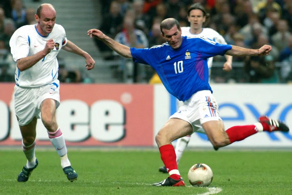 French midfielder Zinedine Zidane shoots the ball in front of Russian captain and defenser Viktor Onopko (L) during the friendly match opposing France to Russia 17 April 2002 at the Stade de France in Saint-Denis, north of Paris.  AFP PHOTO PATRICK HERTZOG (Photo by PATRICK HERTZOG / AFP)