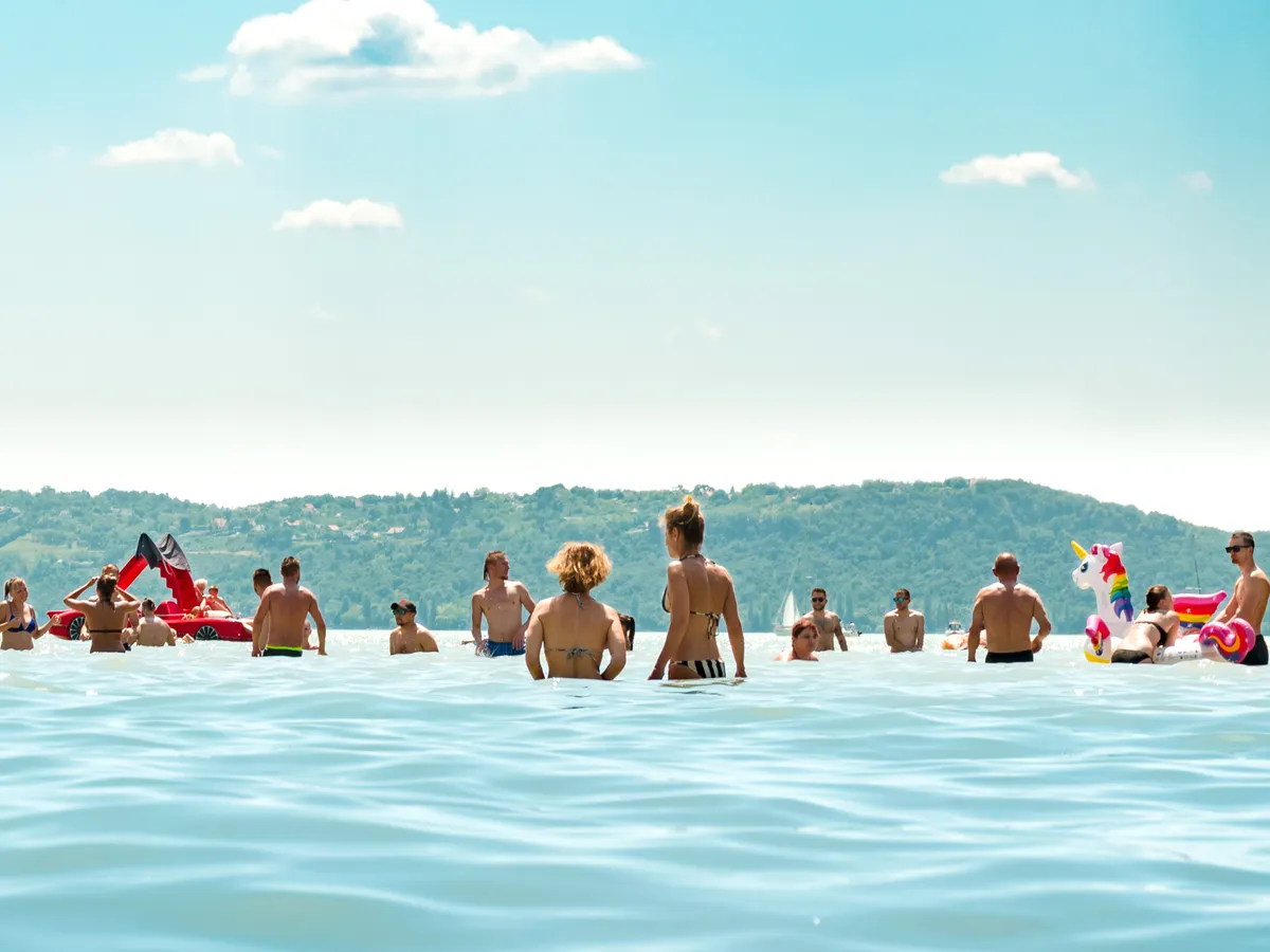 Balatonfured / Hungary - July 20th, 2019: people are having fun, chilling, and swimming in the lake Balaton on a very hot summer day.