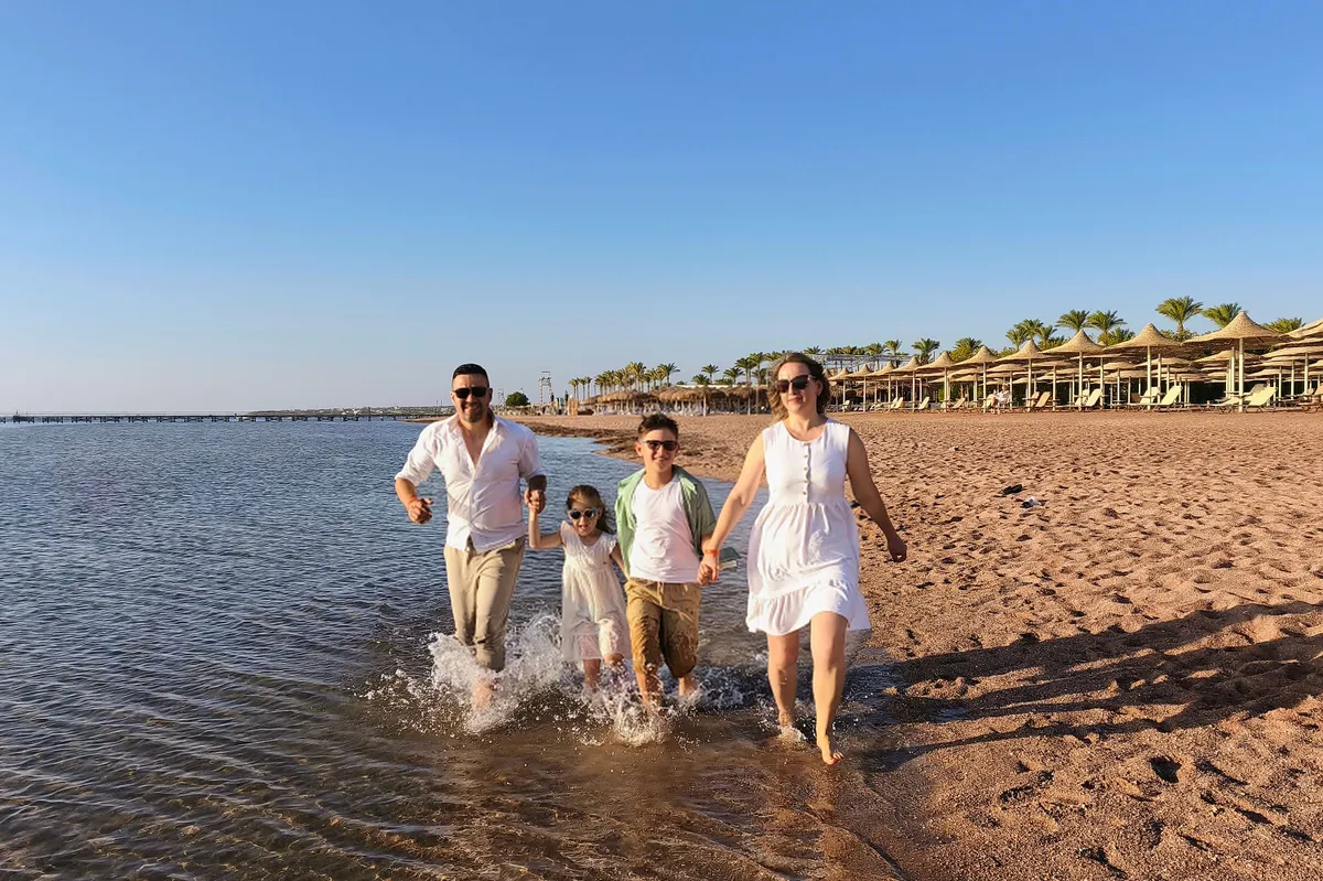 Happy family running on sandy beach. Egypt, Sharm el Sheikh 26.09.2025