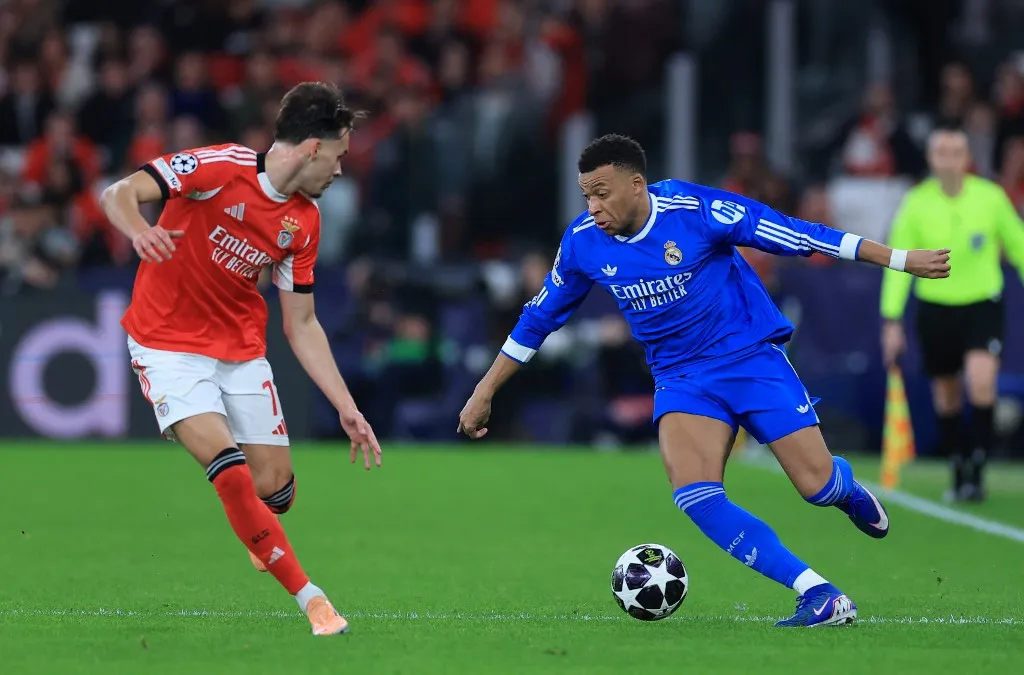 Real Madrid's French forward #10 Kylian Mbappe fights for the ball with SL Benfica's Bosnian defender #17 Amar Dedic during the UEFA Champions League knockout round play-off first leg football match between SL Benfica and Real Madrid CF at Estadio da Luz in Lisbon on February 17, 2026. (Photo by PATRICIA DE MELO MOREIRA / AFP)