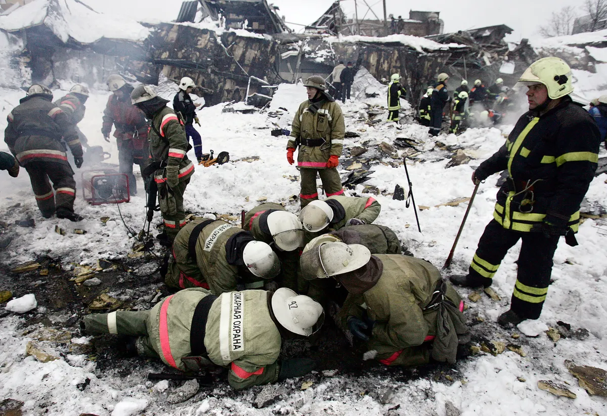 Rescuers work at the wreckage of the collapsed market in Moscow, 23 February 2006. Eighteen people were killed and 24 injured when the roof over an indoor market in Moscow collapsed, Russia's Minister for Emergency Situations Sergei Shoigu said at the site of the accident. AFP PHOTO / TATYANA MAKEYEVA (Photo by TATYANA MAKEYEVA / AFP)