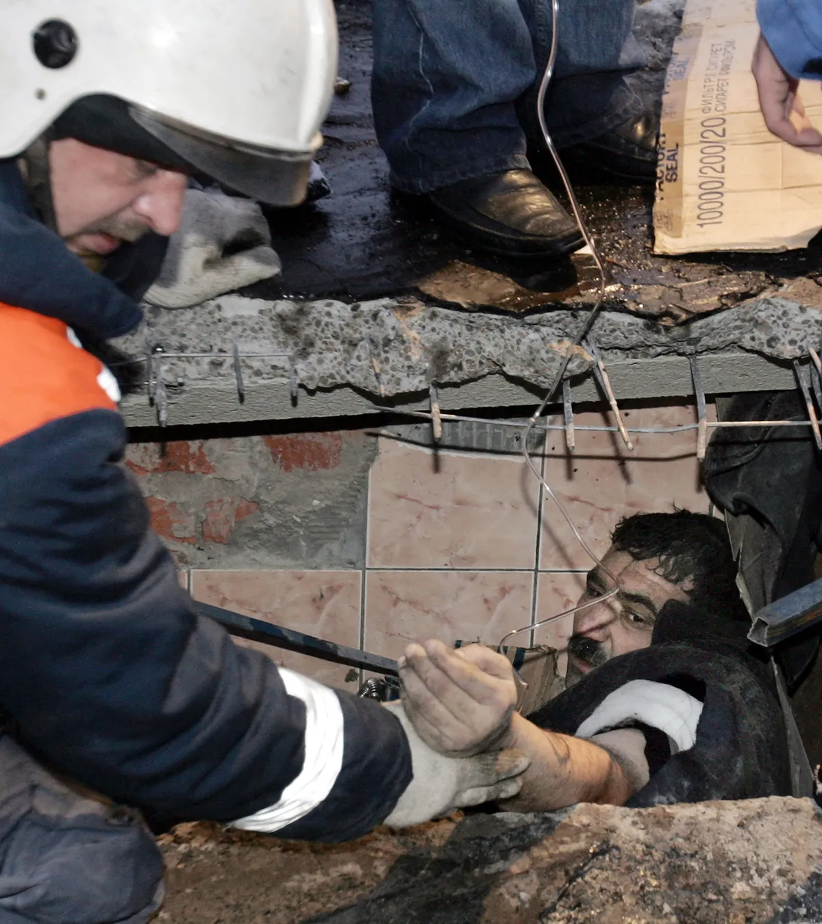 Rescuers help a wounded man at the collapsed market in Moscow, 23 Moscow 2006. Eighteen people were killed and 24 injured when the roof over an indoor market in Moscow collapsed, Russia's Minister for Emergency Situations Sergei Shoigu said at the site of the accident. AFP PHOTO / TATYANA MAKEYEVA (Photo by TATYANA MAKEYEVA / AFP)